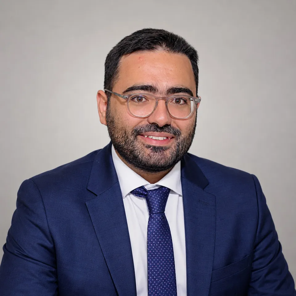 Portrait de Benjamin Lancry, expert-comptable et fondateur de Bayar Consulting, souriant, en lunettes, costume bleu marine et cravate